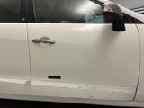 a white car that has a broken door handle on it