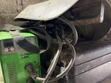 a green welding machine sitting on top of a table