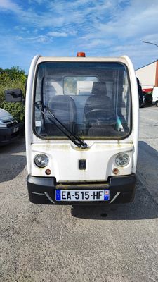 un petit véhicule blanc garé sur un parking