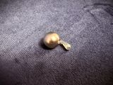 a golden ball with a tassel on it on a gray surface