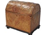 un vieux coffre en bois dont le couvercle est orné d'un motif sculpté