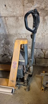 une photo montrant une fourche et une palette dans un garage