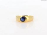 a close up of a gold ring with a blue sapphire stone