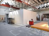 une grande pièce avec un mur blanc et une table rouge à l'intérieur
