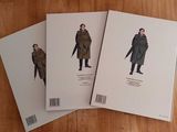 three books on a table with a man in a coat and a woman in a coat