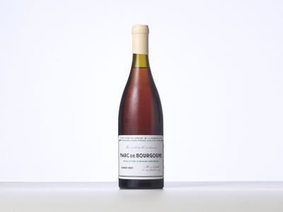 the bottle of wine is sitting on a table with a white background