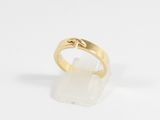 a close up of a gold ring with a white stone on it