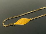 necklace with a gold plated leaf on a chain on a black surface