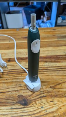 une bouteille posée sur une table à côté d'un chargeur