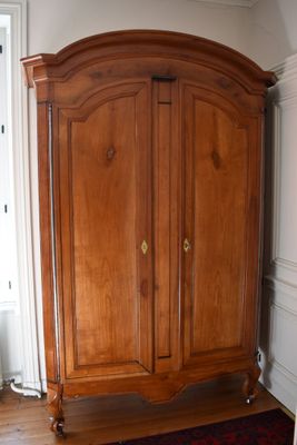 a large wooden armoire in the corner of a room