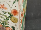 a vase with flowers and birds on it on a stand