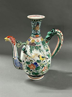 a vase with a bird on it and a bird on the handle