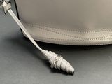 a white purse with a metal handle on a table