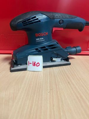 La ponceuse orbitale Bosch est posée sur une table, à côté d'une boîte rouge.