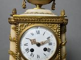 a gold and white clock sitting on top of a table