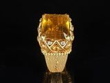 a gold ring with a large citrine stone surrounded by diamonds
