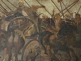 a painting on the wall of a building with people on horses