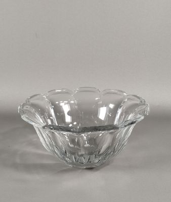 un saladier en verre transparent posé sur une surface blanche, avec un fond gris clair