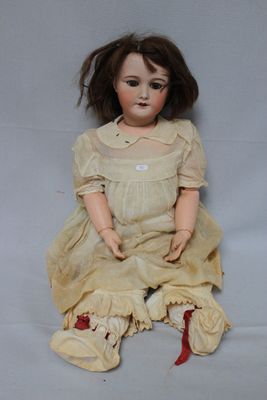an old doll sitting on a white surface with a white background