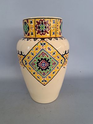 a yellow vase with a colorful design on it