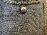 a button that is on the back of a sweater