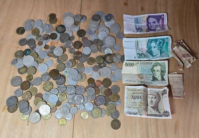 une liasse de billets posée par terre à côté d'un tas de pièces