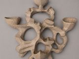 sculpture of a skull made out of clay on a gray surface