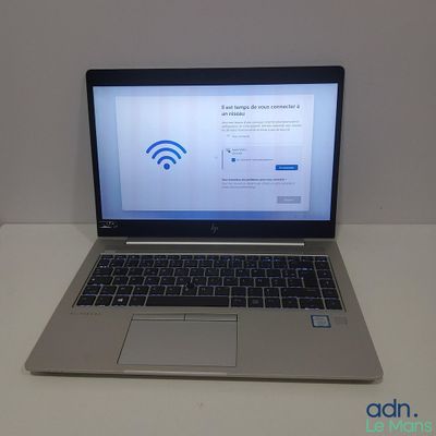 un ordinateur portable posé sur une table, avec le symbole du Wi-Fi affiché à l'écran