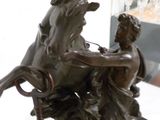 une statue en bronze représentant un homme et une femme sur un cheval