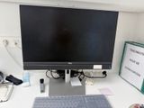 a computer monitor sitting on a desk with a keyboard and mouse