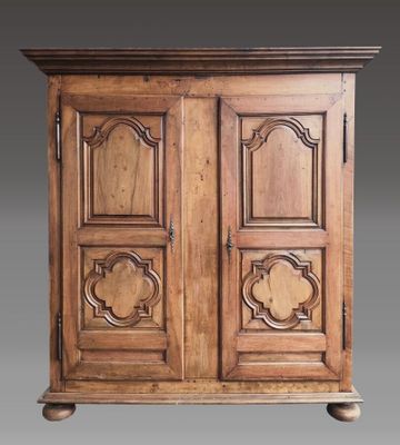 une vieille armoire en bois à deux portes, munie d'une poignée