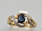 a close up of a gold ring with a blue sapphire and diamonds