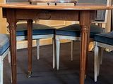 a table with chairs and a vase of flowers on top of it