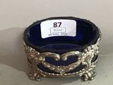 a blue glass bowl with a silver decoration on it