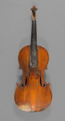 an old violin sitting on top of a table next to a wall