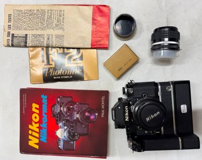 a camera, a book, a camera lens, and other items laid out on a table