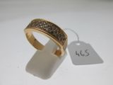 gros plan d'une bague en or avec des diamants sur une surface blanche