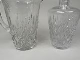 two glass vases and a glass bottle on a table
