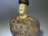 a ceramic figurine of a man with a hat on his head