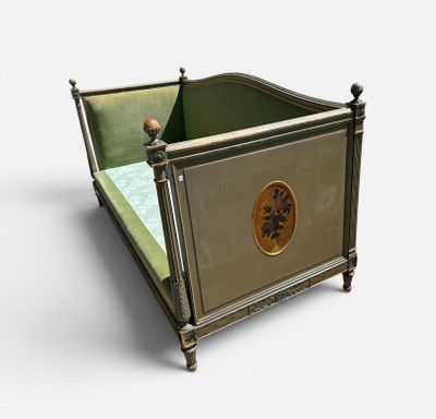un petit lit orné d'un médaillon doré