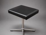 un tabouret en cuir noir avec un piètement en acier chromé