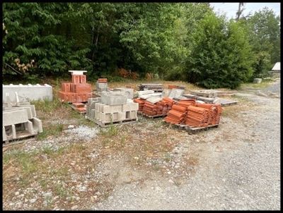 un tas de briques posé par terre à côté d'un tas d'ordures