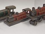 several toy trains are lined up in a row on a white surface