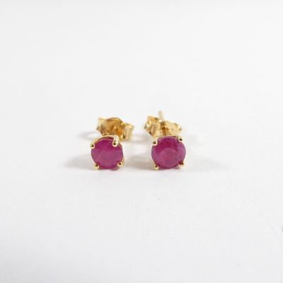 une paire de boucles d'oreilles à clous ornées de pierres roses sur fond blanc
