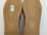 the soles of a pair of brown shoes on a white surface