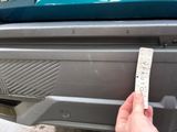 a hand that is holding a piece of paper in front of a car