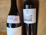 deux bouteilles de vin posées sur une étagère l'une à côté de l'autre