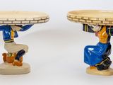 deux figurines représentant un homme portant un plateau sur la tête