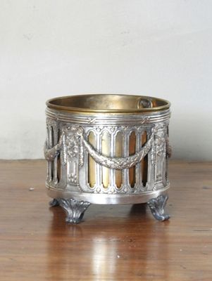 un petit bougeoir en argent posé sur une table en bois