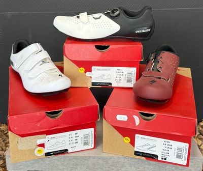 trois paires de chaussures sont posées sur des cartons posés par terre